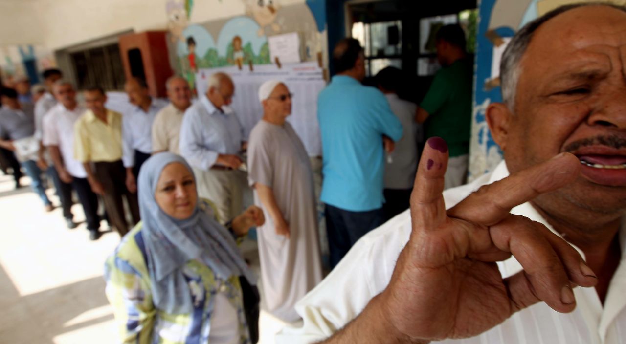 An Egyptian man shows off his little finger covered in indelible ink after casting his vote at a polling station in Cairo.