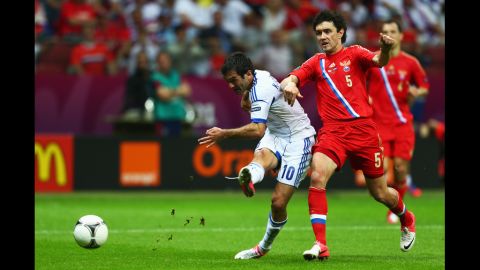 Giorgos Karagounis of Greece scores the opening goal under pressure from Yuriy Zhirkov of Russia during the match between Greece and Russia on Saturday.