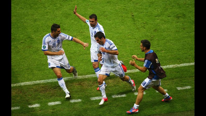 Giorgos Karagounis of Greece, center, celebrates scoring the opening goal with teammates, left to right, Kostas Katsouranis, Giannis Maniatis and Sotiris Ninis during the match between Greece and Russia.