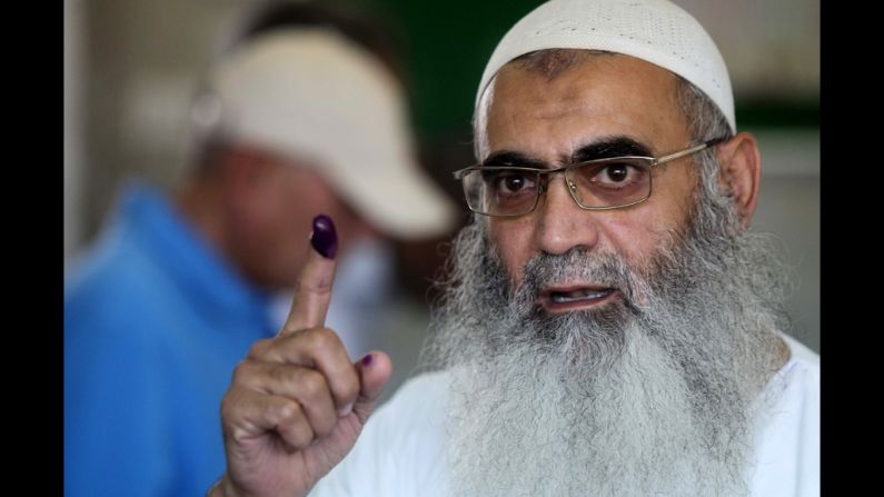 An Egyptian Muslim Salafist shows his ink-stained finger after voting at a polling station.