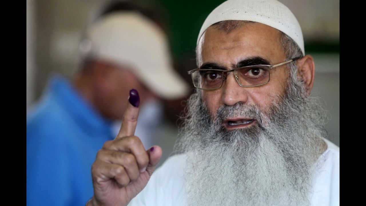 An Egyptian Muslim Salafist shows his ink-stained finger after voting at a polling station.