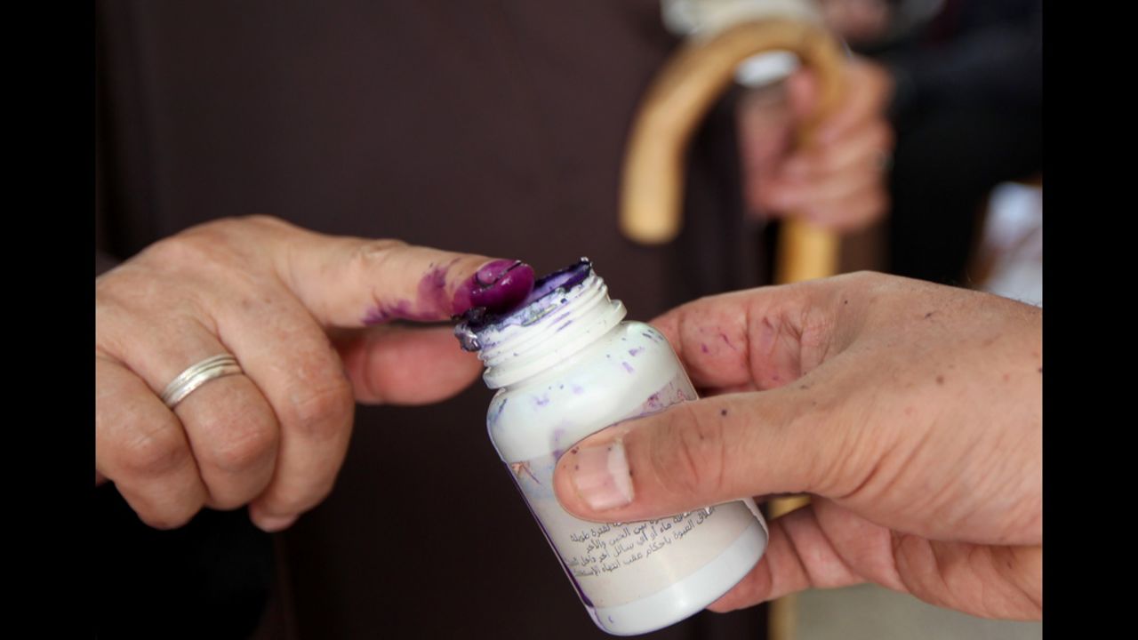 An Egyptian woman dips her finger in indelible ink after casting her ballot.