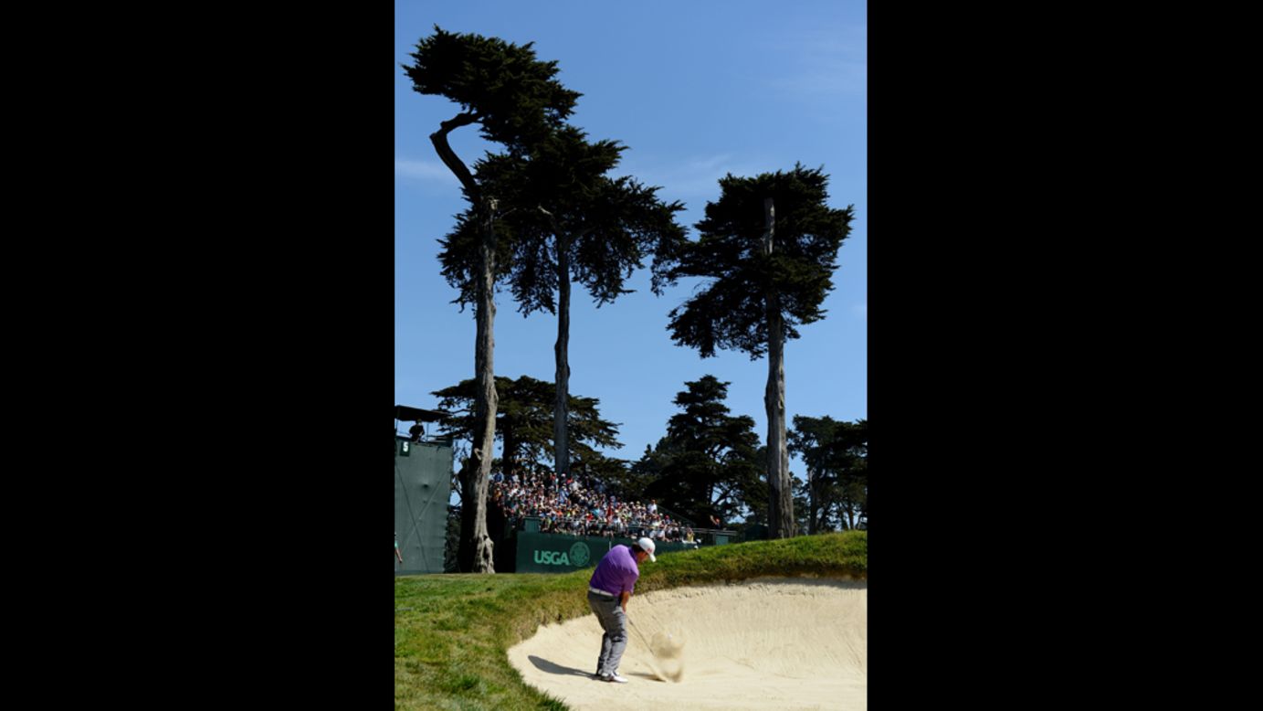 Graeme McDowell of Northern Ireland hits a bunker shot on the fifth hole during the third round.
