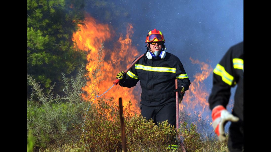 A firefighter works on extinguishing a brush fire in the eastern Athens area of Keratea. Two brush fires broke out in Greece on Saturday, including one near seaside resorts close to Athens, just a day ahead of crucial elections.