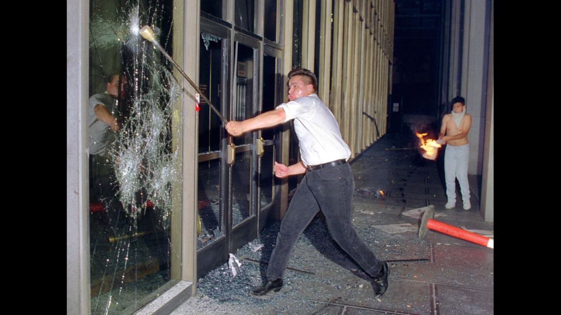 A rioter breaks a glass door of the Criminal Courts building in downtown Los Angeles on April 29.