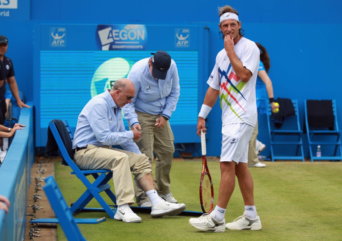 David Nalbandian stands next to line judge Andrew McDougall whose leg was gashed in the incident at Queen's Club. 