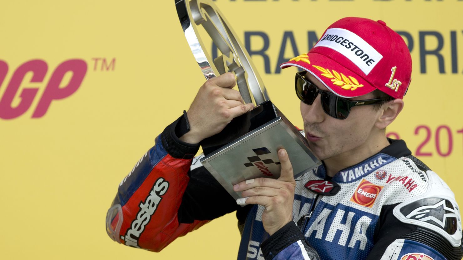Jorge Lorenzo gets up close and personal with the trophy after winning the British MotoGP..