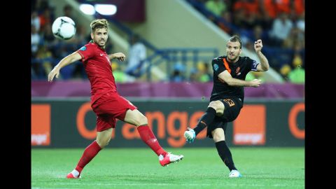 Rafael van der Vaart of the Netherlands scores the opening goal past Miguel Veloso of Portugal.