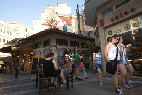 Young Greek people walk through Psiri, an area regarded as one of Athens most vibrant art and cultural centers. However, business has dropped by 60%, and crime has increased, local workers say.