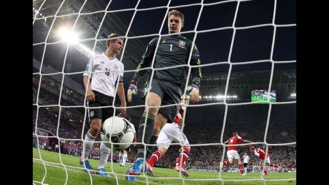 Philipp Lahm and Manuel Neuer of Germany walk toward the ball after Michael Krohn-Dehli of Denmark scored.