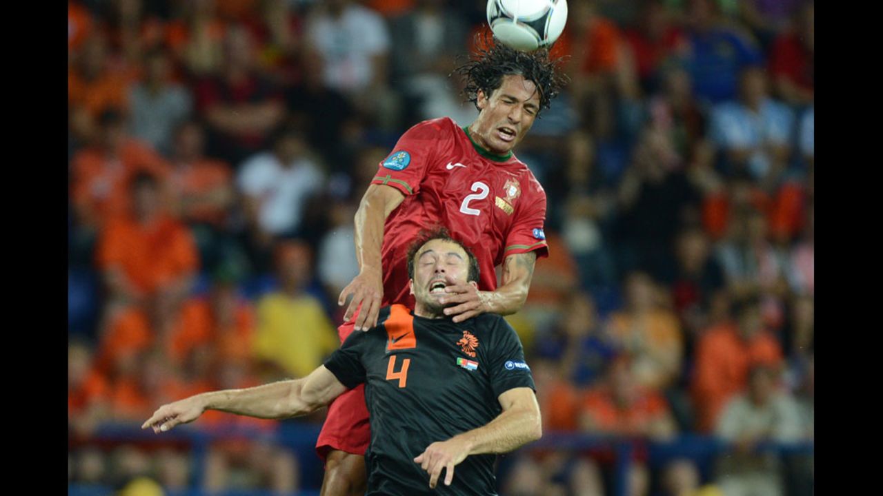 Portugal's Bruno Alves battles Joris Mathijsen of the Netherlands for control of the ball.