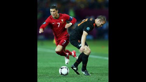 Cristiano Ronaldo of Portugal competes with Ron Vlaar of the Netherlands.