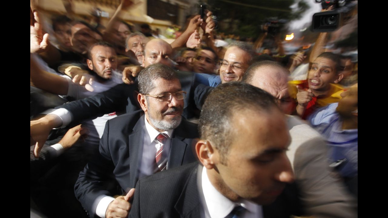 The Muslim Brotherhood's Mohamed Morsi makes his way through supporters at electoral headquarters early Monday in Cairo. In a victory speech, Morsi did not address the military council's move but tried to allay fears he would impose an Islamist state.