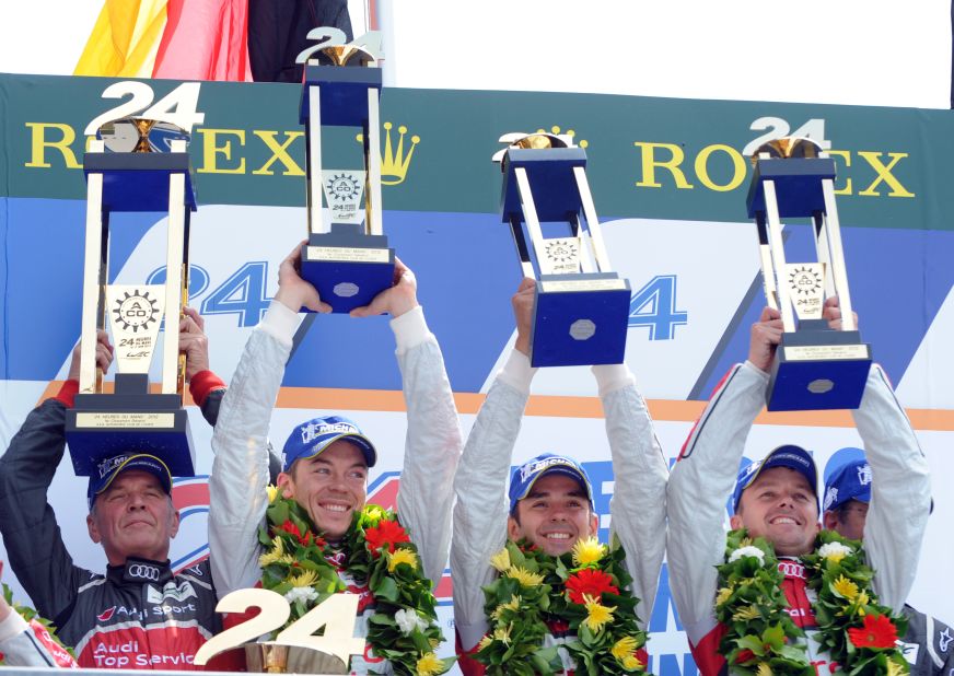Audi motorsport director Dr. Wolfgang Ullrich, left, celebrates on the podium with his drivers after the team's victory in the 80th edition of the race.