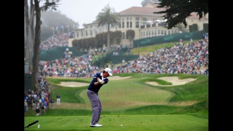 Webb Simpson of the United States hits his tee shot on the eighth hole.