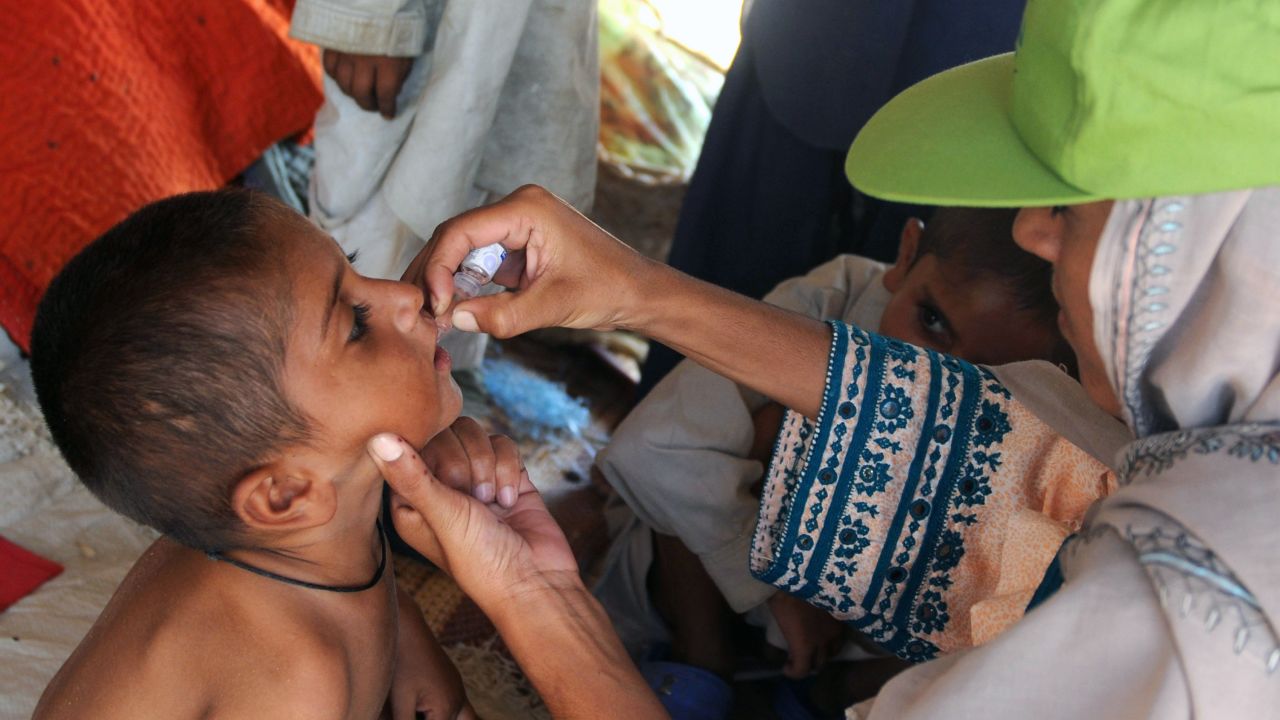 A Pakistan health worker gives polio drops at a makeshift camp on the outskirts of Karachi on September 29, 2010.