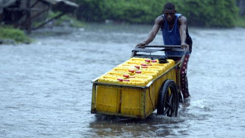 A man in Lagos wades through the aftermath of a heavy downpour in 2012.