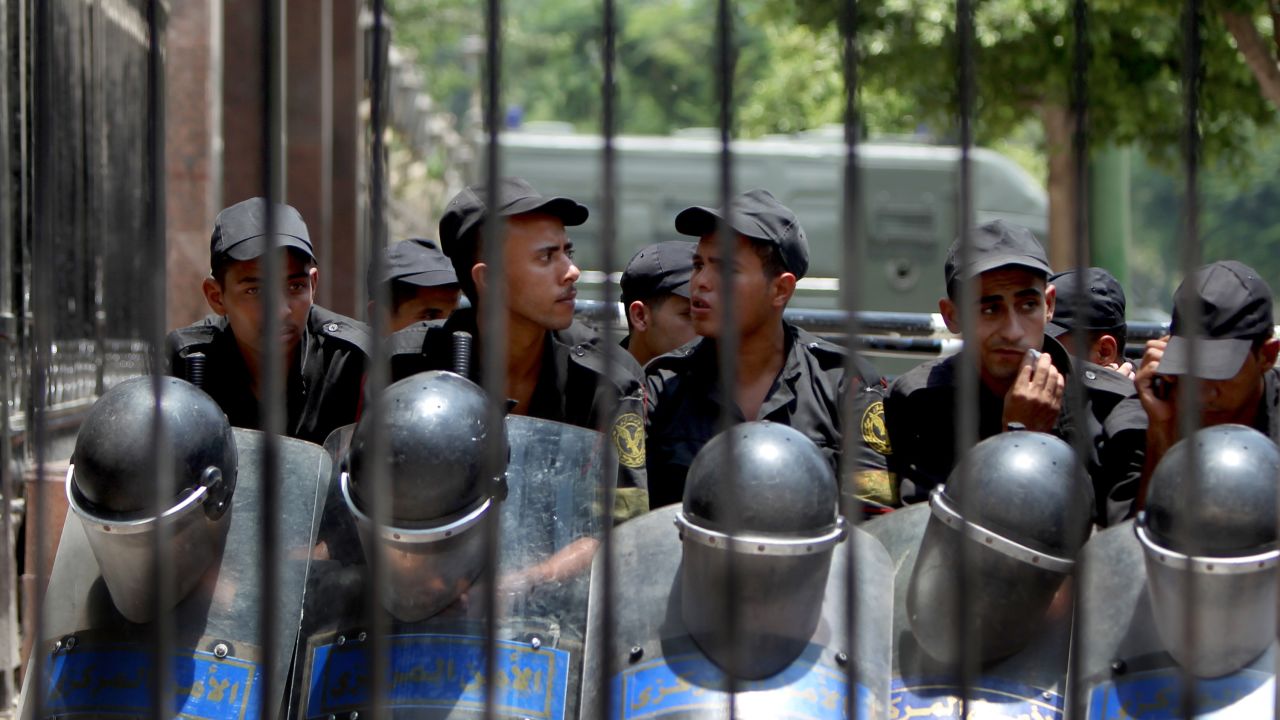 Egyptian riot police stand outside the parliament as protesters gather in Cairo on Tuesday.