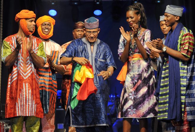 Models applaud Niger fashion designer Alphadi -- shown holding the Senegalese flag -- at the end of the opening day on June 12. 