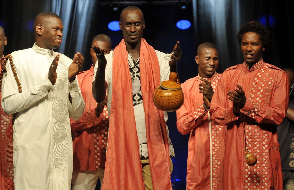 Senegalese designer Amdou Diop, center, thanks the crowd following his show.  