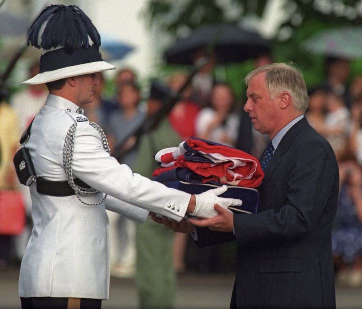 Chris Patten, the 28th and last governor of British colonial Hong Kong, receives the Union Jack flag after it was lowered for the last time at Government House on June 30, 1997.