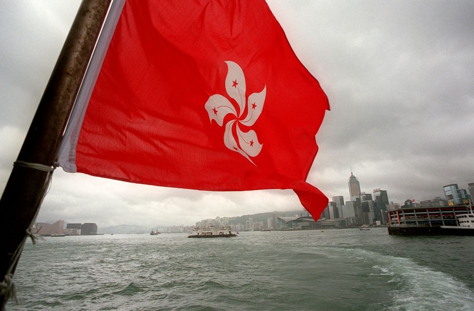 The new Hong Kong Special Administrative Region flag featuring a Bauhinia flower flies over the city from a ferry boat on July 2, 1997. 