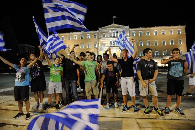 Greek football fans celebrate their win over Russia outside their parliament and on the eve of Sunday's key elections.