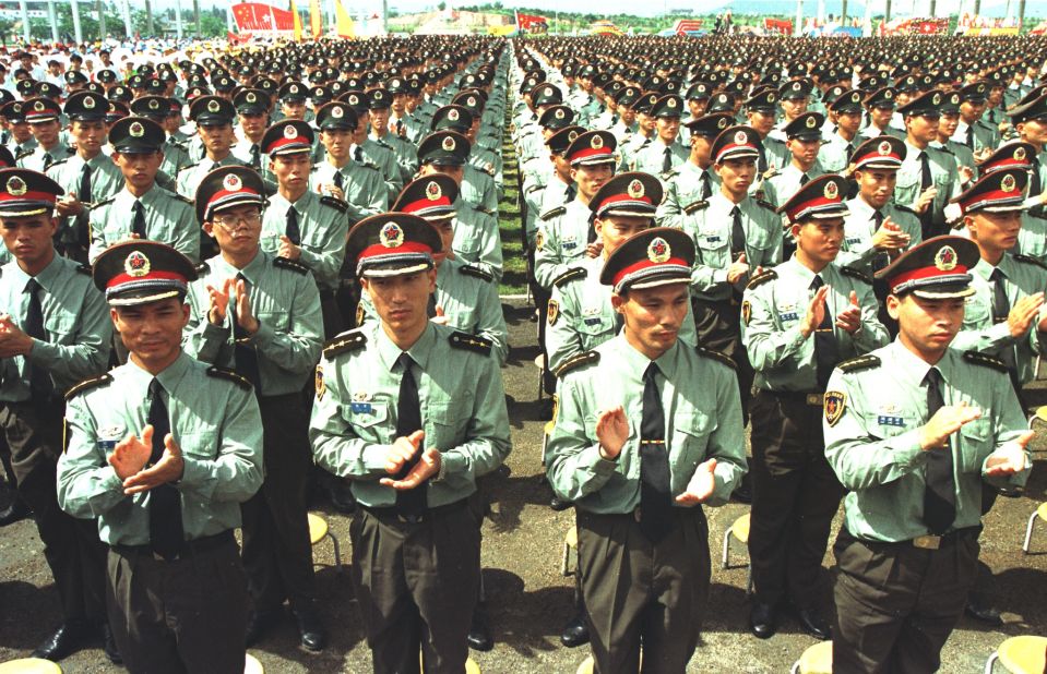 Hong Kong Garrison People's Liberation Army soldiers applaud during a farewell ceremony attended by the Chinese Central Military Commission in Shenzhen, China, on June 30, 1997.  The soldiers entered Hong Kong before the change of sovereignty became effective at midnight.