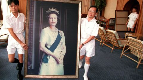 Two Royal Navy sailors carry a portrait of Queen Elizabeth through the British Forces' Hong Kong headquarters as her pictures are taken down ahead of the handover of Hong Kong in 1997.