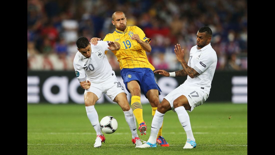 Emir Bajrami of Sweden gets tackled by France's Hatem Ben Arfa, left, and Yann M'Vila during a Group D match Tuesday in Kiev, Ukraine.