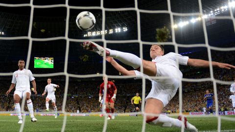 England's John Terry scrambles to clear an effort from Marko Devic which appeared to have crossed the line 