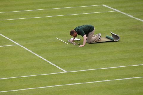 A member of the Wimbledon ground staff monitors one of the test areas on Centre Court.