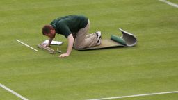 A member of the Wimbledon ground staff monitors one of the test areas on Centre Court.