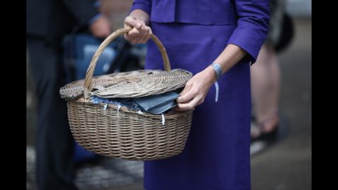  A dress code assistant holds a basket of pashminas at the main entrance to Royal Ascot. Visitors are expected to keep to a strict dress code.