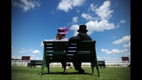 Race-goers sit together on a bench.