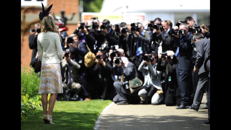 A race-goer poses for photographers at the races.