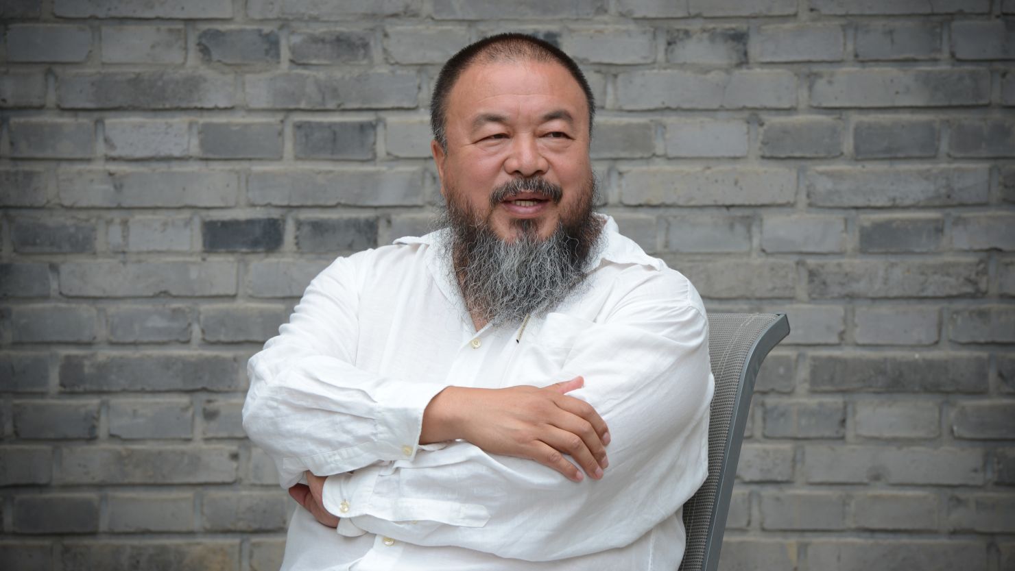 Chinese artist Ai Weiwei waits at his home after claiming he was barred from attending a court hearing in Beijing on June 20, 2012. 
