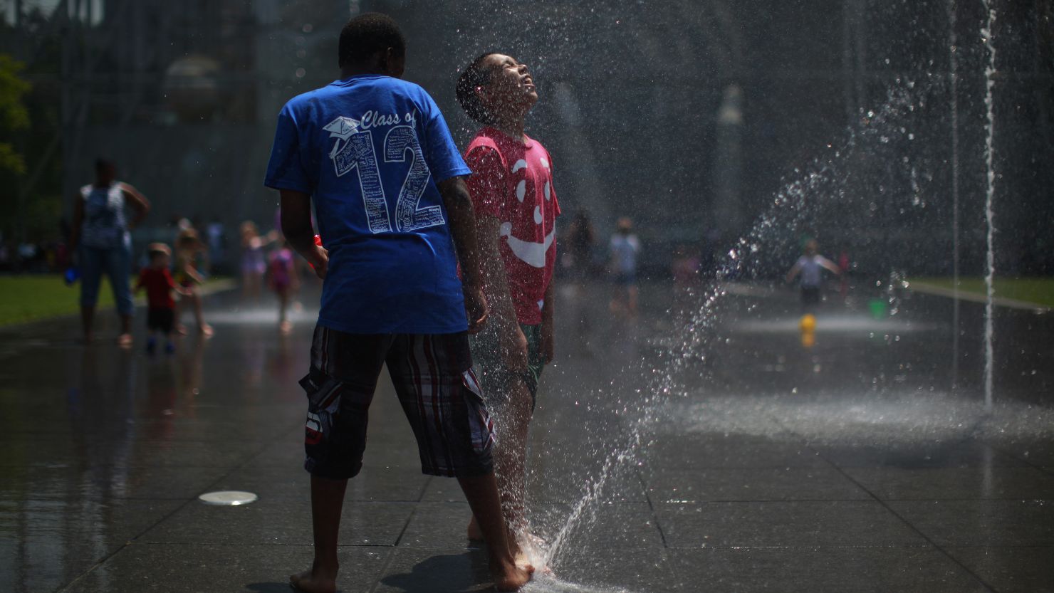 Children play at a fountain Wednesday in New York, where temperatures reached the mid-90s.