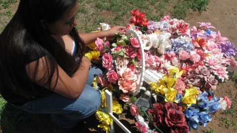 Melinda Williams pays tribute at the grave of her mother, Floridna Gotcher.