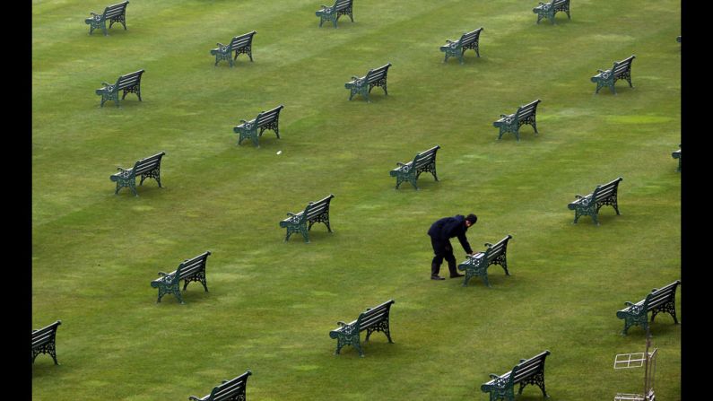 A worker checks benches in the grandstand.