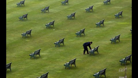 A worker checks benches in the grandstand. 