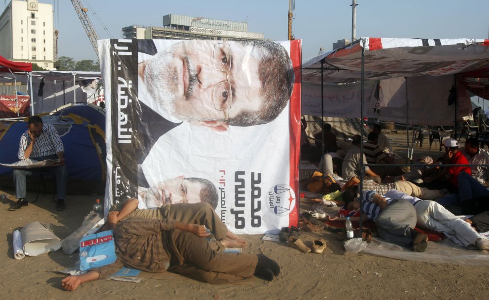Egyptian activists rest at the foot of a banner of presidential candidate Mohamed Morsi in Cairo's Tahrir Square on Thursday, June 21. 