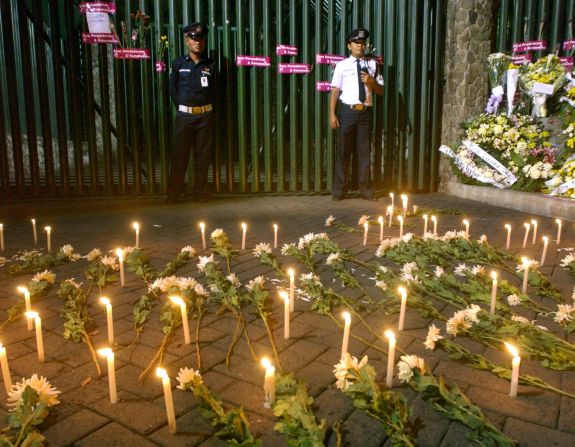 Two security guards stand in front of the Australian Embassy's front gate, where Indonesians placed candles and flowers to express their condolences for the victims of the Bali bombings.