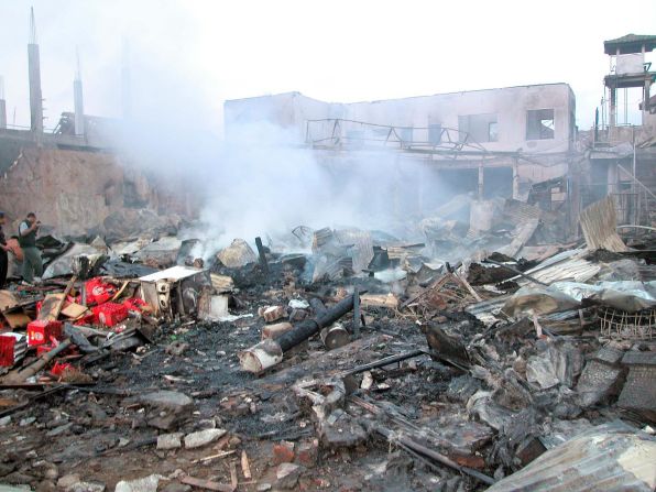 Smoke rises from the debris at the site of the bomb blasts. The first was detonated inside Paddy's Bar on Jelan Legian in Kuta, according to the Australian Federal Police. It was followed by a second, larger blast from a van parked near the Sari Club, then a third near the U.S. Consulate in Renon, Denpasar.