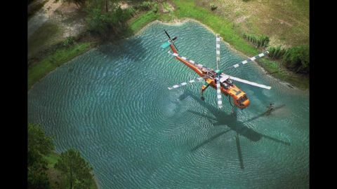 This is Greer's award-winning image of an Erickson Air-Crane dipping into a pond to fill its tank on the Oakhead Complex Fire in Osceola National Forest, Florida. The image won first place in the "aerial resources" category of a Fire & Aviation Management photo contest in 2004.