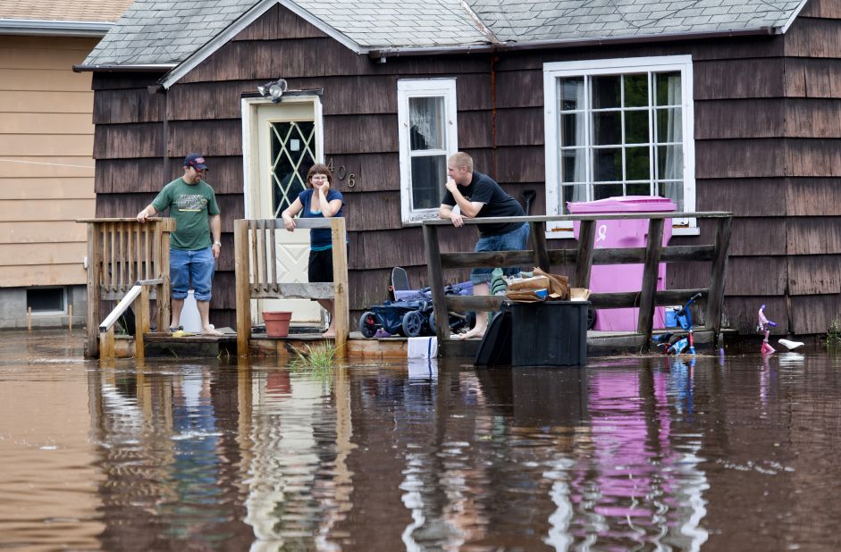Friends of Tyler Dewsbury wait for help Wednesday so they can move belongings from his flooded house in Carlton, southwest of Duluth.