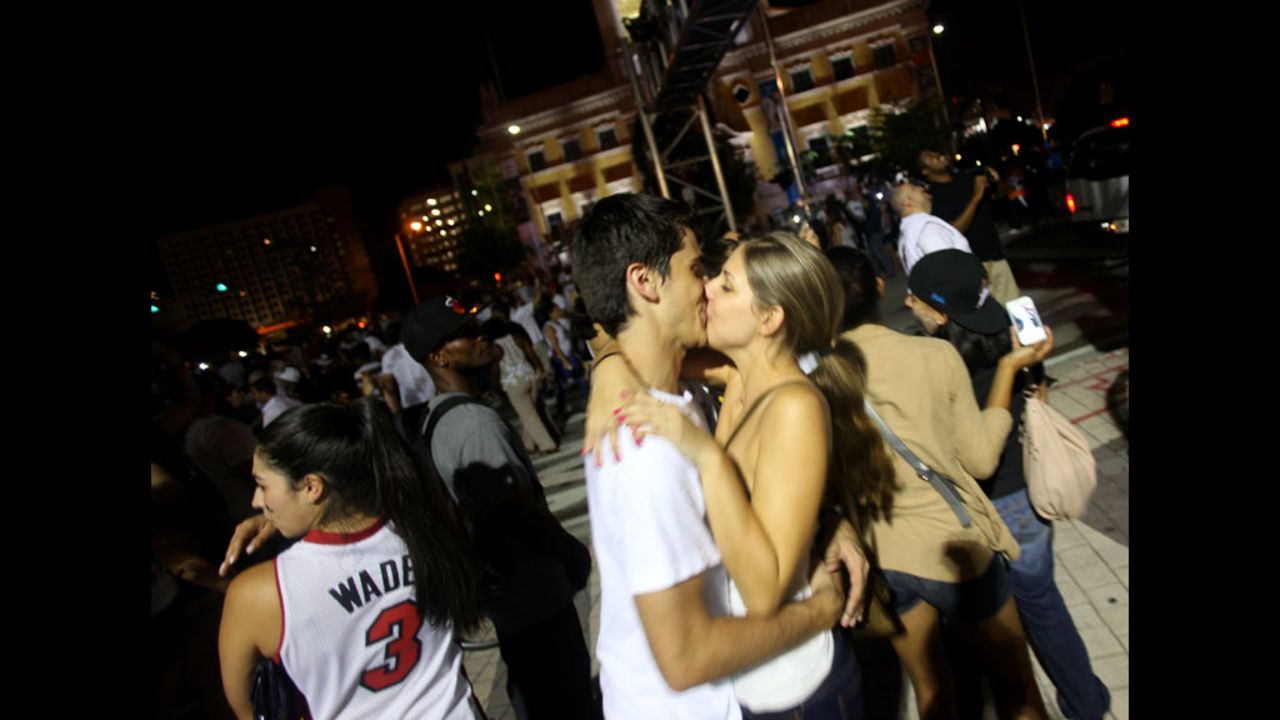 A couple kisses as Miami Heat fans celebrate the Heat's victory over the Oklahoma City Thunder in the 2012 NBA Finals in Miami.