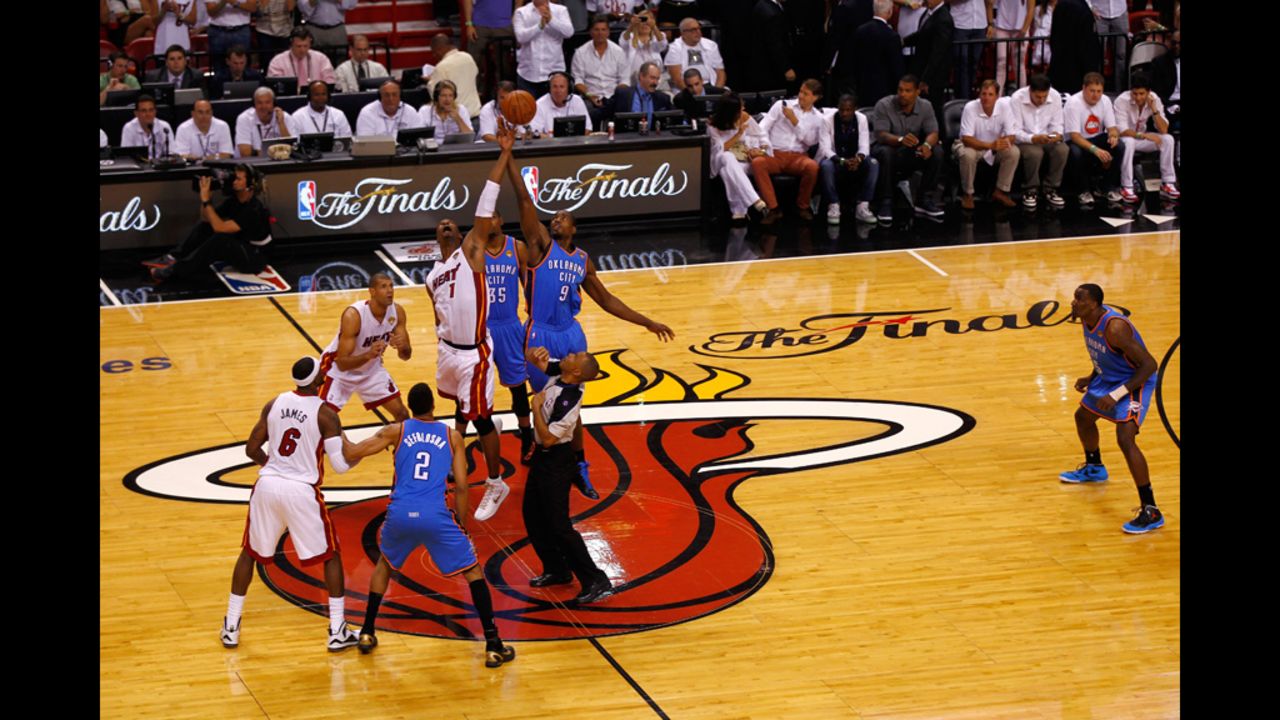 Chris Bosh, No. 1 of the Heat, fights for control of the opening tip-off against Serge Ibaka, No. 9 of the Thunder.