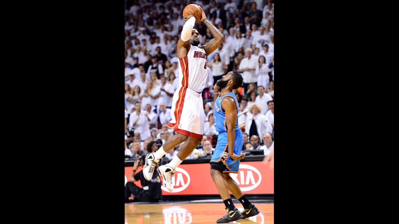 LeBron James, No. 6 of the Heat, attempts a shot in the first half against James Harden, No. 13 of the Thunder.