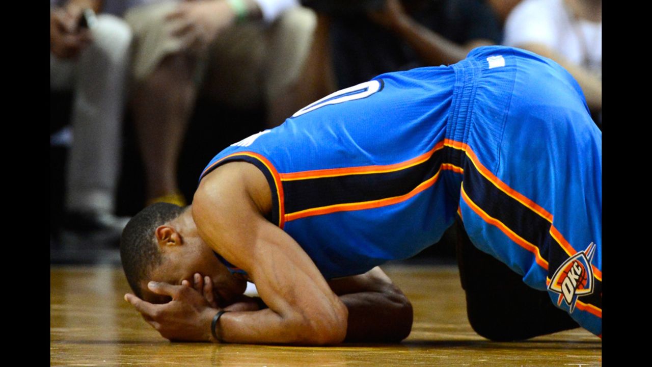 Russell Westbrook No. 0 of the Thunder covers his face as he kneels on the court in the second half against the Heat.